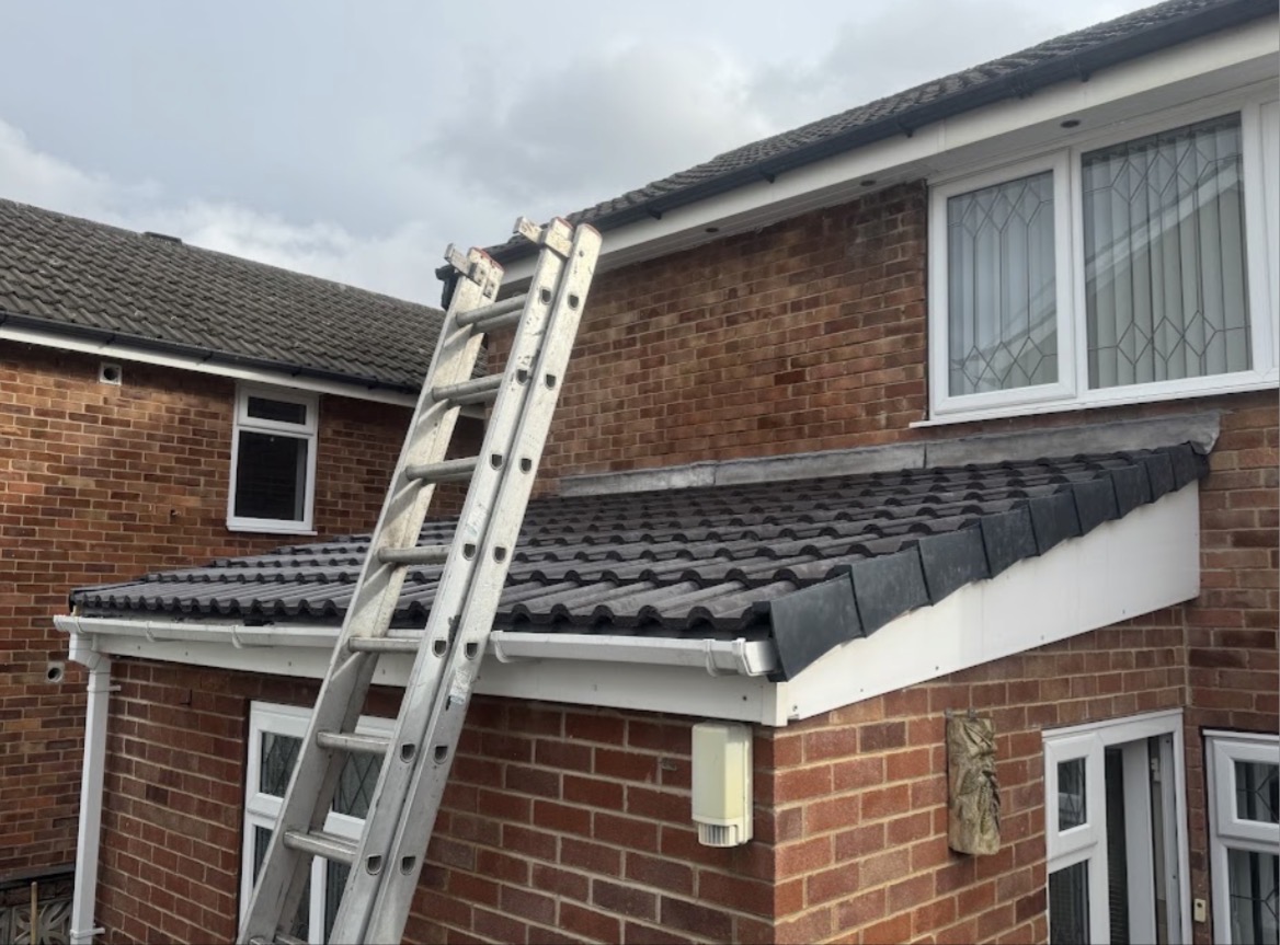 Lean-to extension with newly laid charcoal concrete tiles, lead flashing and white fascias