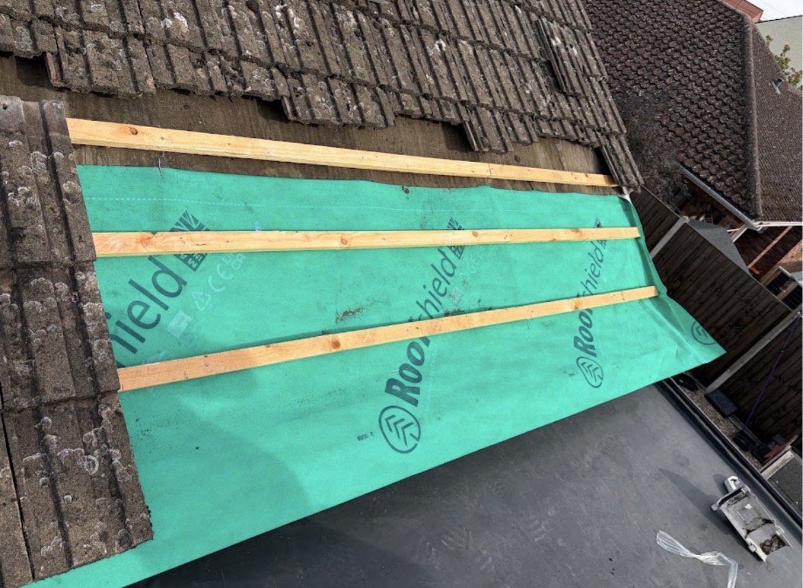 Roof repair with green breathable membrane and new timber battens beneath existing tiles