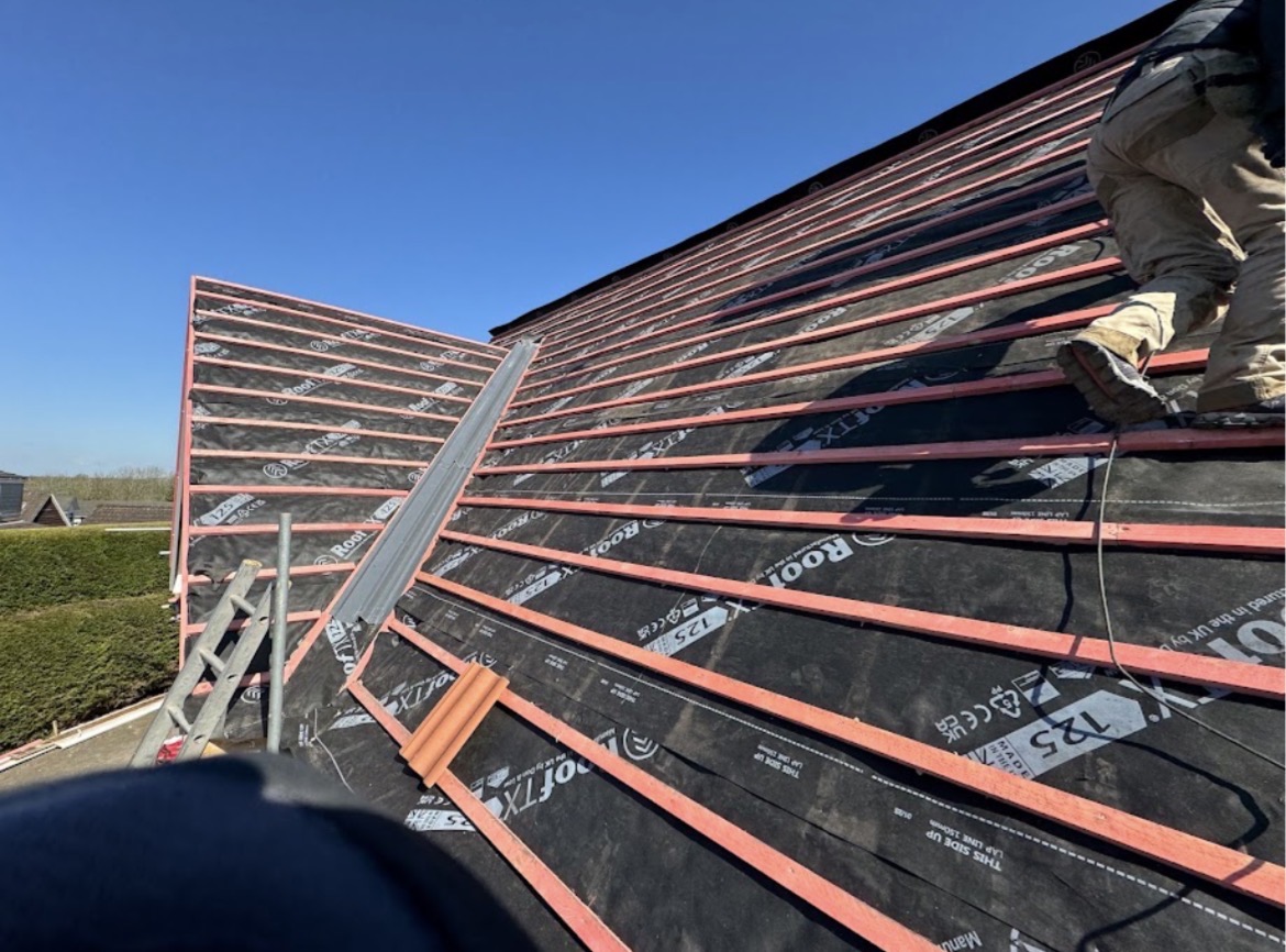 Red-treated timber battens, black underlay and a new grey metal valley trough on a multi-pitched roof