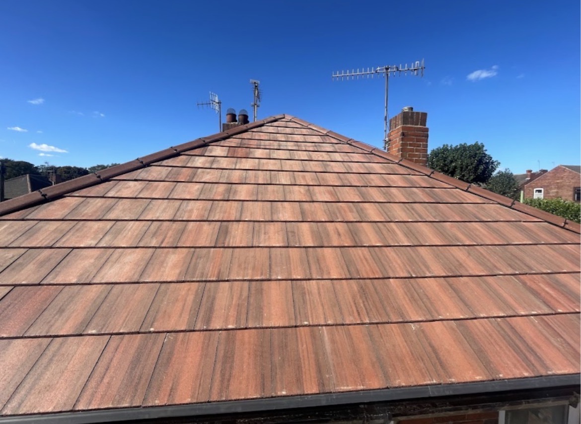 Newly installed hipped pitched roof covered in reddish-brown interlocking tiles