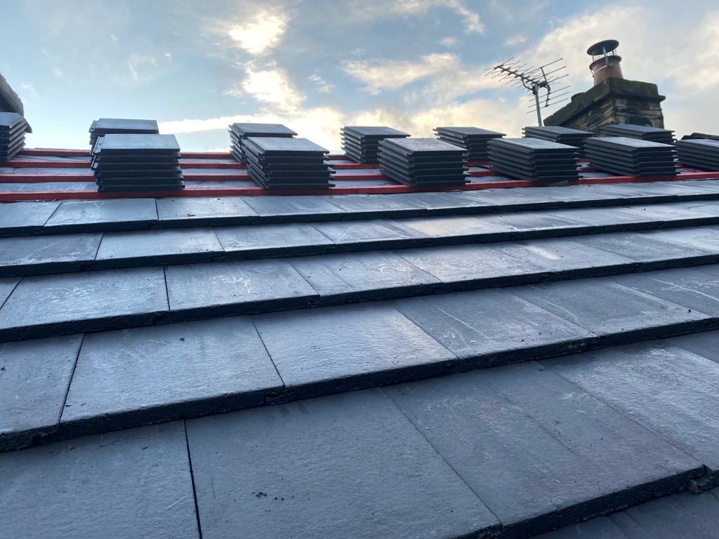New slate roof with fresh tiles stacked on the battens