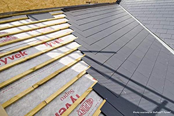 Roof valley with dark grey slates partially laid over treated battens and white breathable membrane