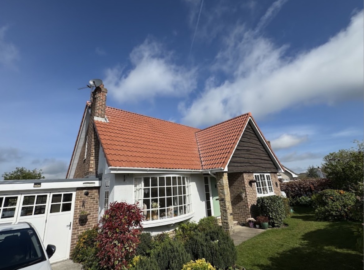 Detached bungalow with a complete terracotta red tiled cross-gable roof